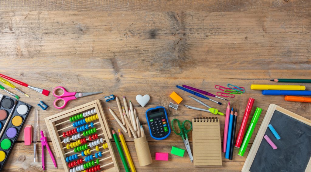 Back to school. School supplies on wooden background, top view